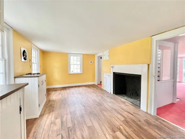 a view of a livingroom with wooden floor and a fireplace