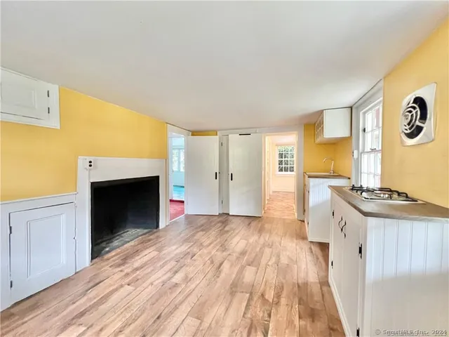 a view of a kitchen with wooden floor and a fireplace