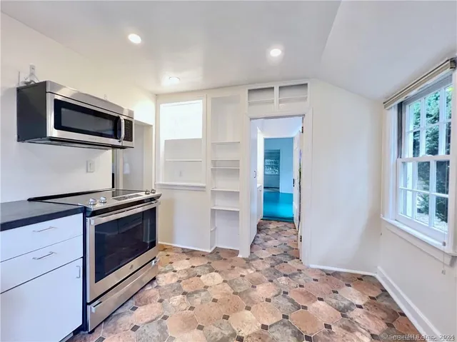 a kitchen with stainless steel appliances kitchen island granite countertop a stove and a sink