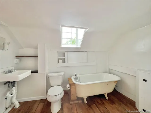 a bathroom with a toilet a sink and mirror