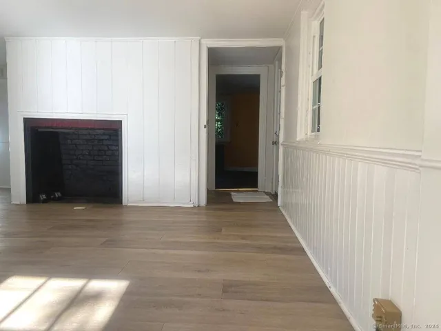 a view of a hallway with wooden floor and a fireplace