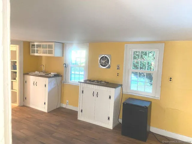 a kitchen with granite countertop white cabinets and wooden floor