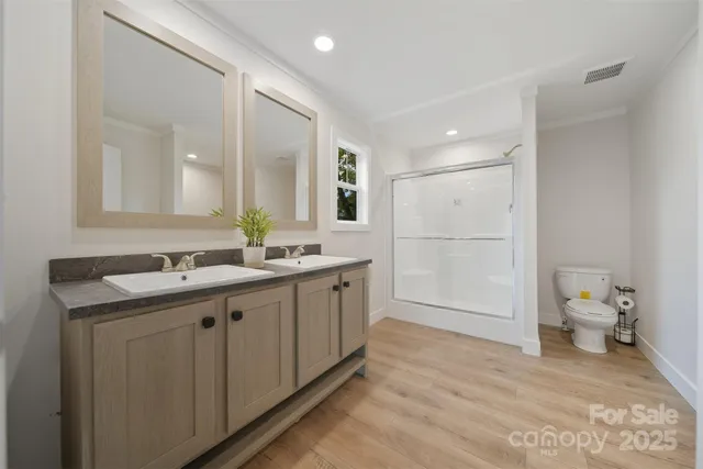 a spacious bathroom with a double vanity sink toilet and a mirror