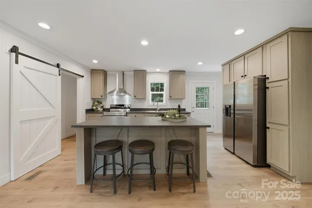 a kitchen with stainless steel appliances granite countertop a refrigerator a sink and a stove