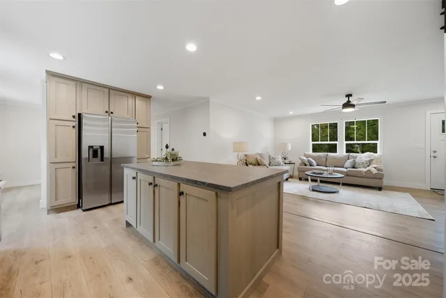 a kitchen with stainless steel appliances kitchen island granite countertop a refrigerator and a stove top oven