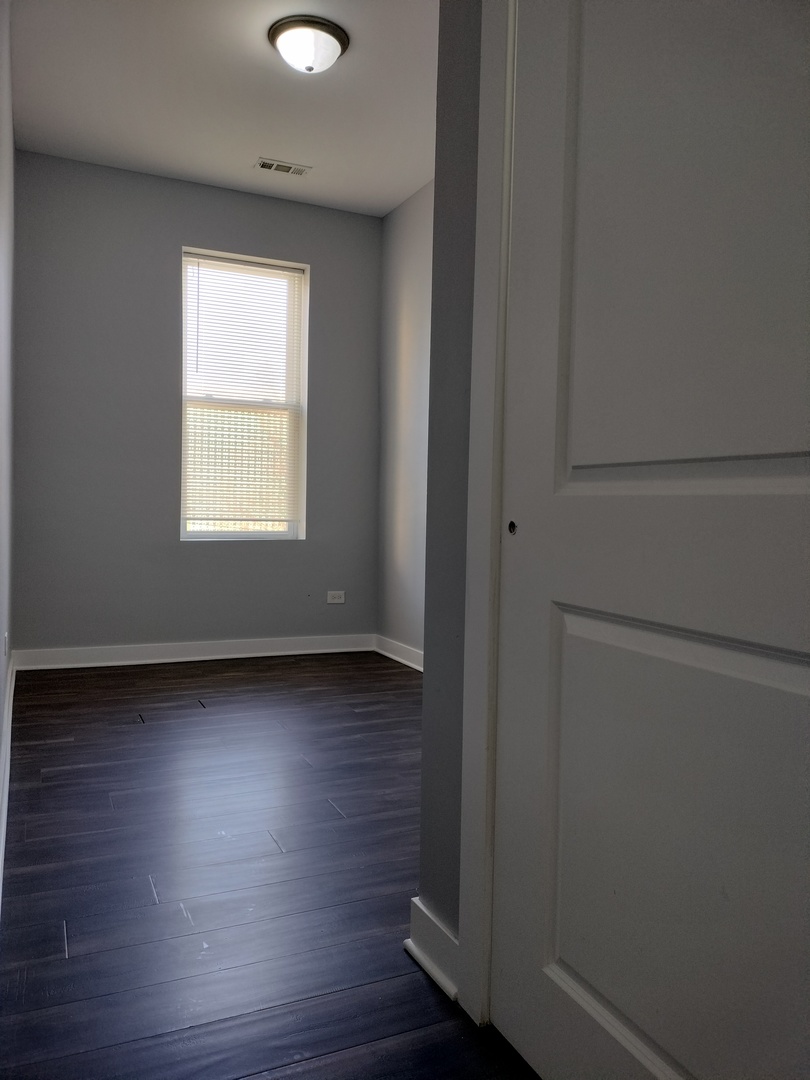 1945 West 48th Street, Unit 2 Chicago, IL 60609 - Photo 12 of 19 a room with wooden floor and windows