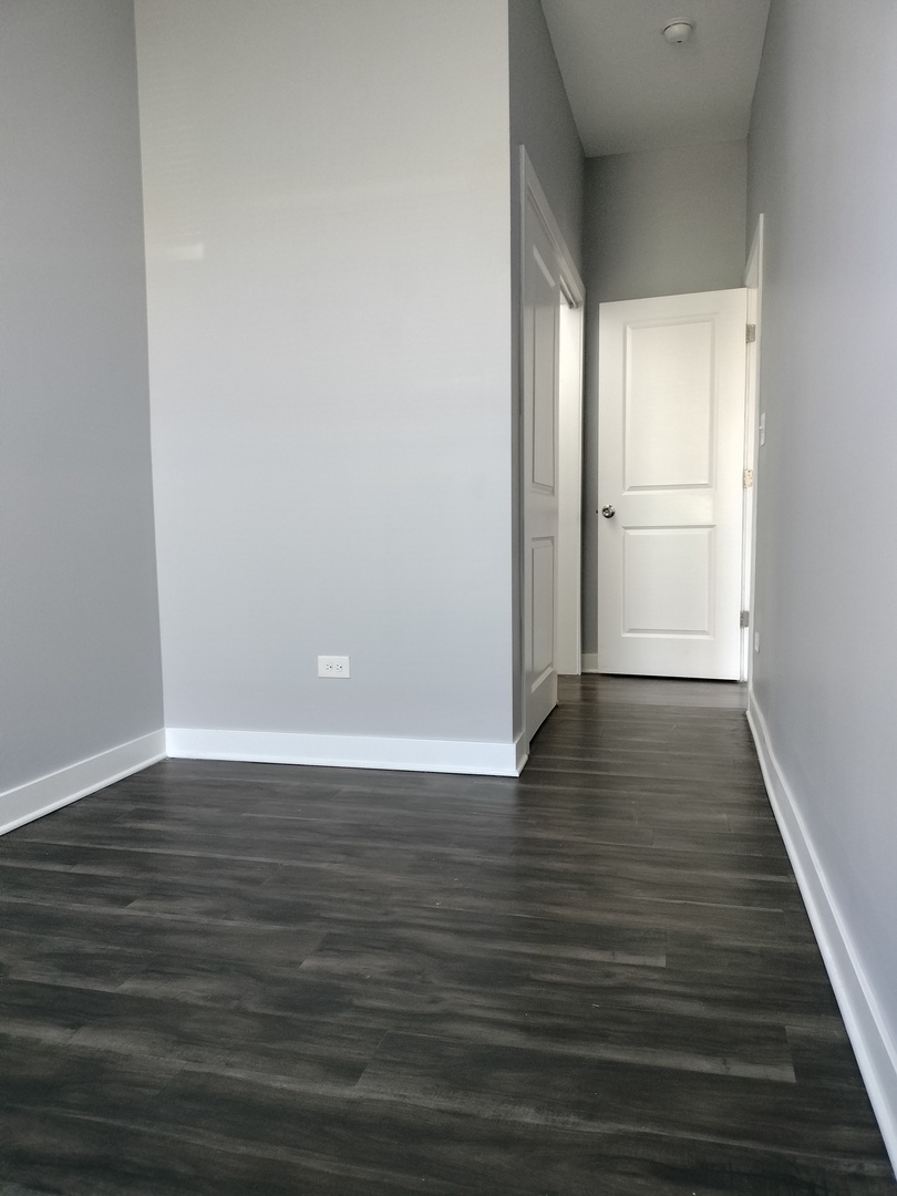 1945 West 48th Street, Unit 2 Chicago, IL 60609 - Photo 13 of 19 a view of an empty room with wooden floor and a window