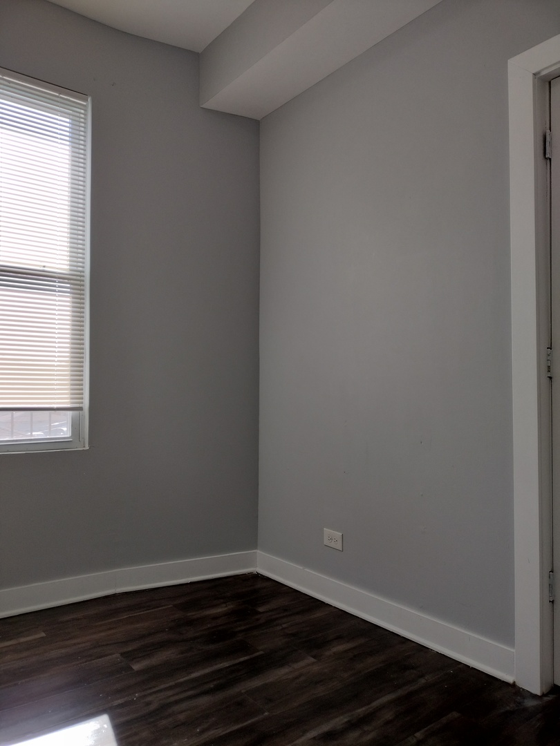 1945 West 48th Street, Unit 2 Chicago, IL 60609 - Photo 15 of 19 a view of an empty room with wooden floor and a window