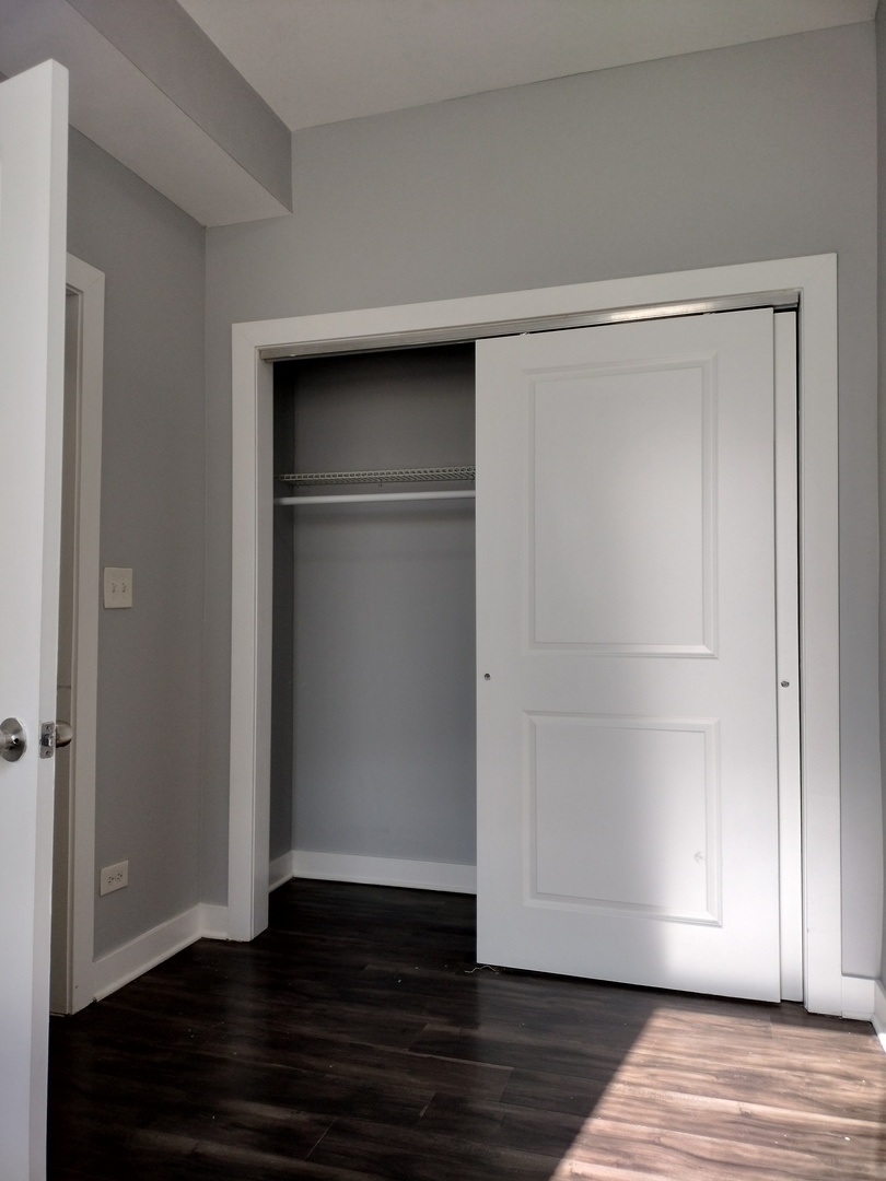 1945 West 48th Street, Unit 2 Chicago, IL 60609 - Photo 16 of 19 a view of an empty room with wooden floor & closet
