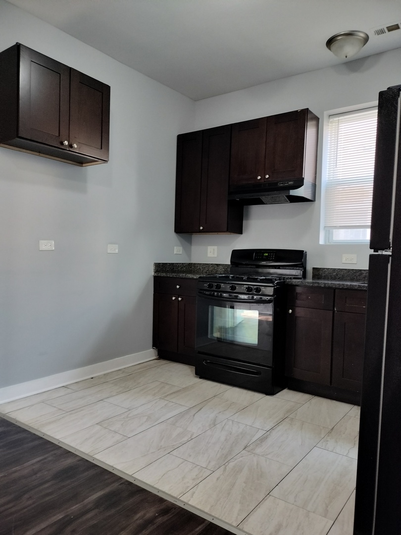 1945 West 48th Street, Unit 2 Chicago, IL 60609 - Photo 6 of 19 a kitchen with a stove and a microwave