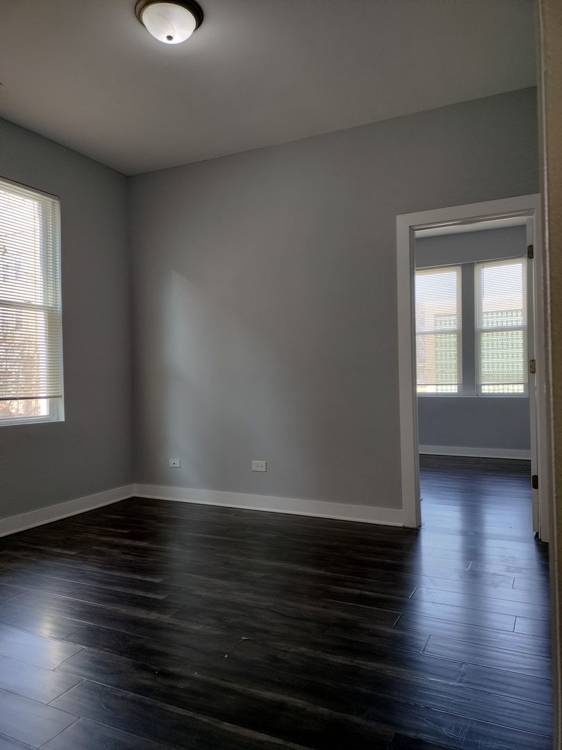 1945 West 48th Street, Unit 2 Chicago, IL 60609 - Photo 8 of 19 an empty room with wooden floor and windows