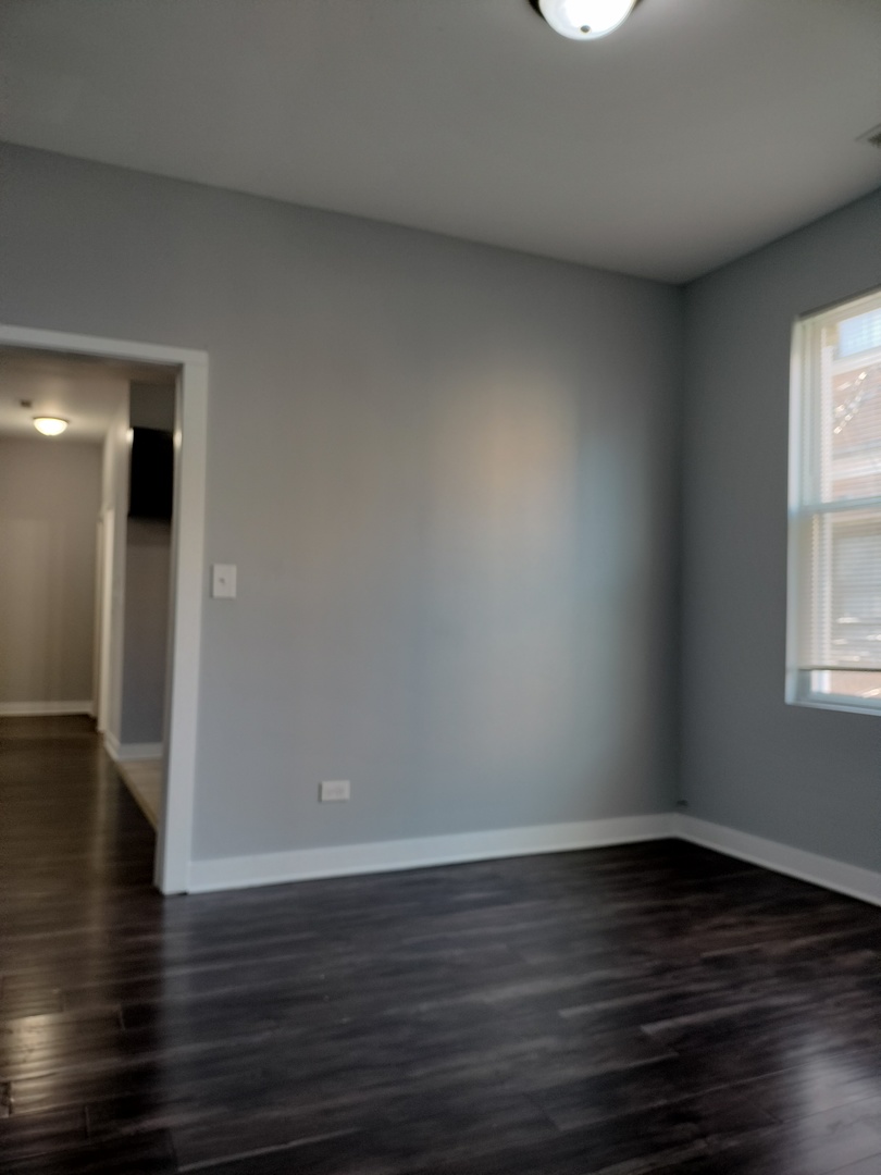 1945 West 48th Street, Unit 2 Chicago, IL 60609 - Photo 9 of 19 a view of an empty room with wooden floor and a window