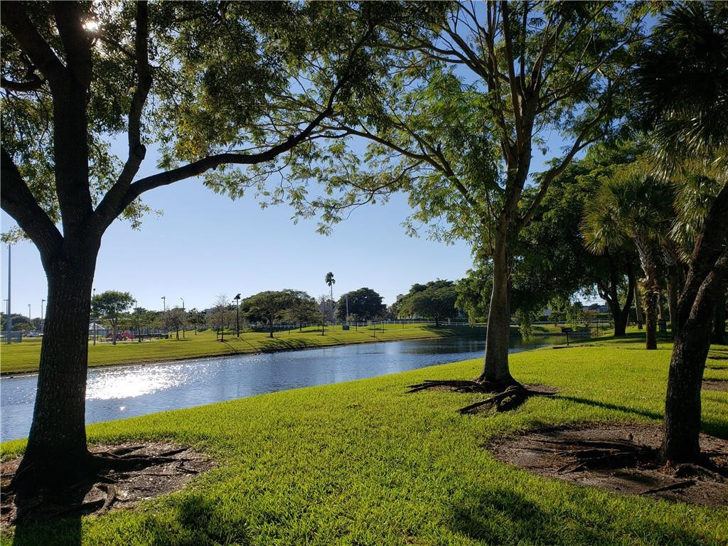 7930 North Nob Hill Road, Unit 3305 Tamarac, FL 33321 - Photo 18 of 28 a view of a lake with houses in the back