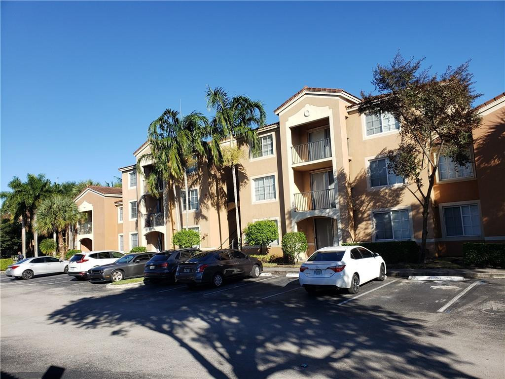 7930 North Nob Hill Road, Unit 3305 Tamarac, FL 33321 - Photo 3 of 28 a view of a building with cars parked in front of it