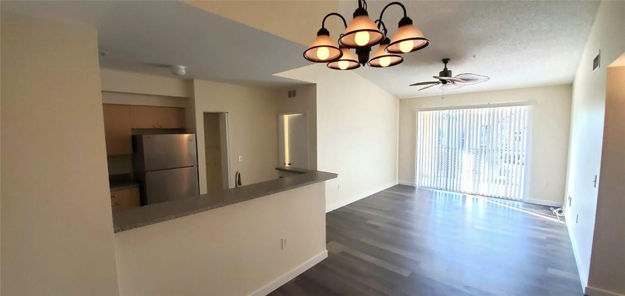 7930 North Nob Hill Road, Unit 3305 Tamarac, FL 33321 - Photo 4 of 28 a view of a livingroom with wooden floor and chandelier