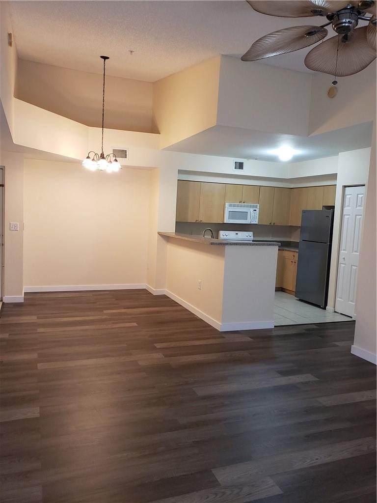 7930 North Nob Hill Road, Unit 3305 Tamarac, FL 33321 - Photo 7 of 28 a kitchen with kitchen island stainless steel appliances a stove refrigerator and wooden floor