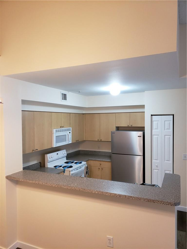 7930 North Nob Hill Road, Unit 3305 Tamarac, FL 33321 - Photo 8 of 28 a kitchen with a refrigerator and a sink