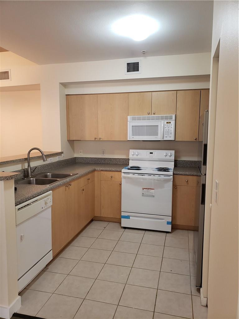 7930 North Nob Hill Road, Unit 3305 Tamarac, FL 33321 - Photo 9 of 28 a kitchen with a stove sink and cabinets