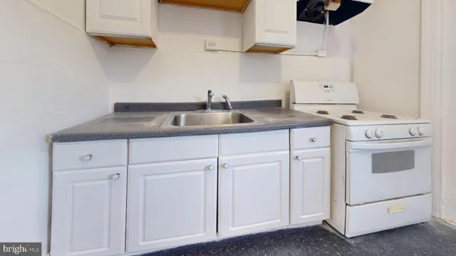 a kitchen with white cabinets and white appliances