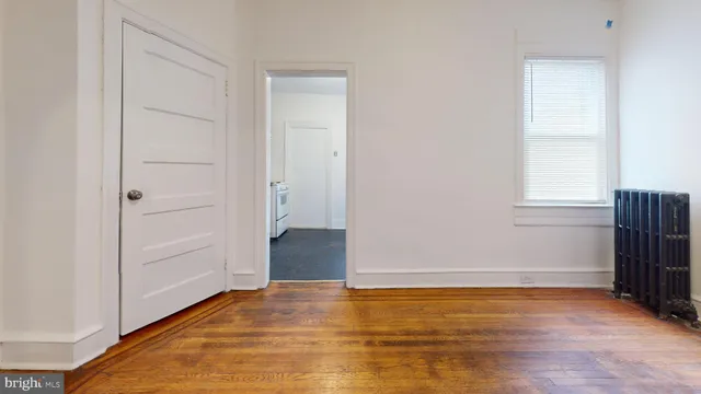 a view of empty room with wooden floor