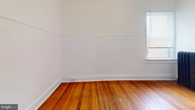 a view of a room with wooden floor and small window
