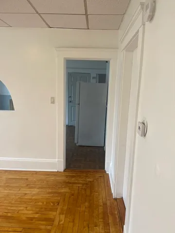 a view of empty room with wooden floor