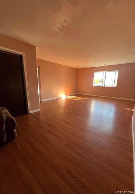 15 Park Avenue, Unit 302B Spring Valley, NY 10977 - Photo 5 of 7 an empty room with wooden floor and windows