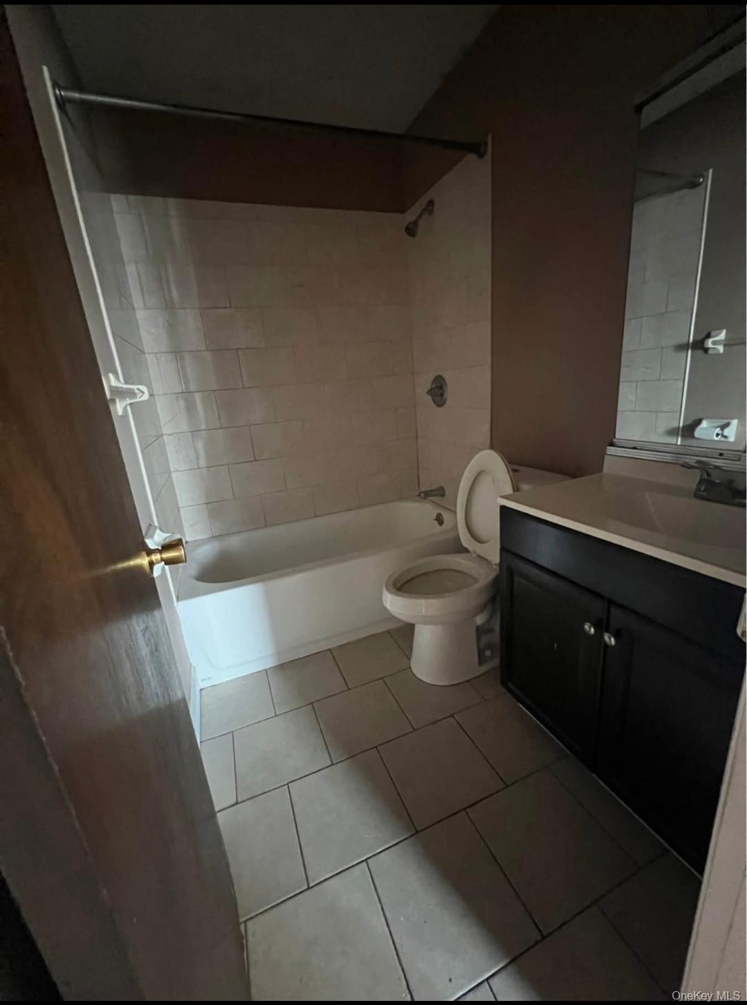 15 Park Avenue, Unit 302B Spring Valley, NY 10977 - Photo 6 of 7 a bathroom with a granite countertop bathtub toilet and sink