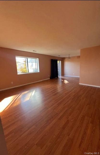 15 Park Avenue, Unit 302B Spring Valley, NY 10977 - Photo 7 of 7 an empty room with wooden floor and windows