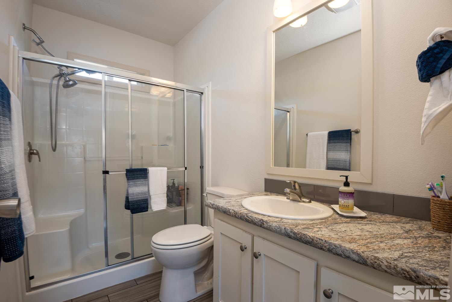 3904 Walker View Road Wellington, NV 89444 - Photo 17 of 37 a bathroom with a granite countertop sink toilet and shower