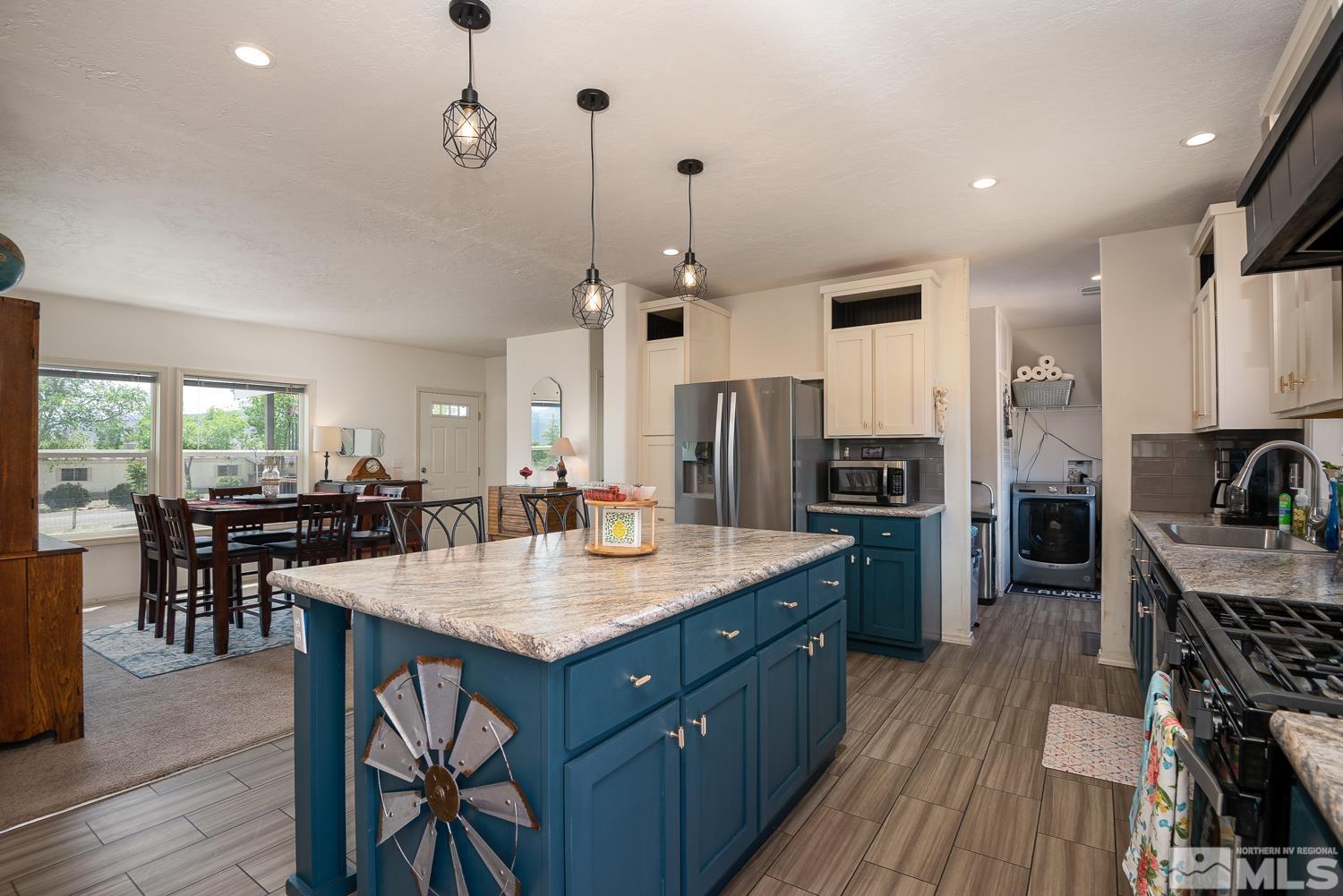 3904 Walker View Road Wellington, NV 89444 - Photo 6 of 37 a kitchen with stainless steel appliances granite countertop a stove refrigerator and a dining table with wooden floor
