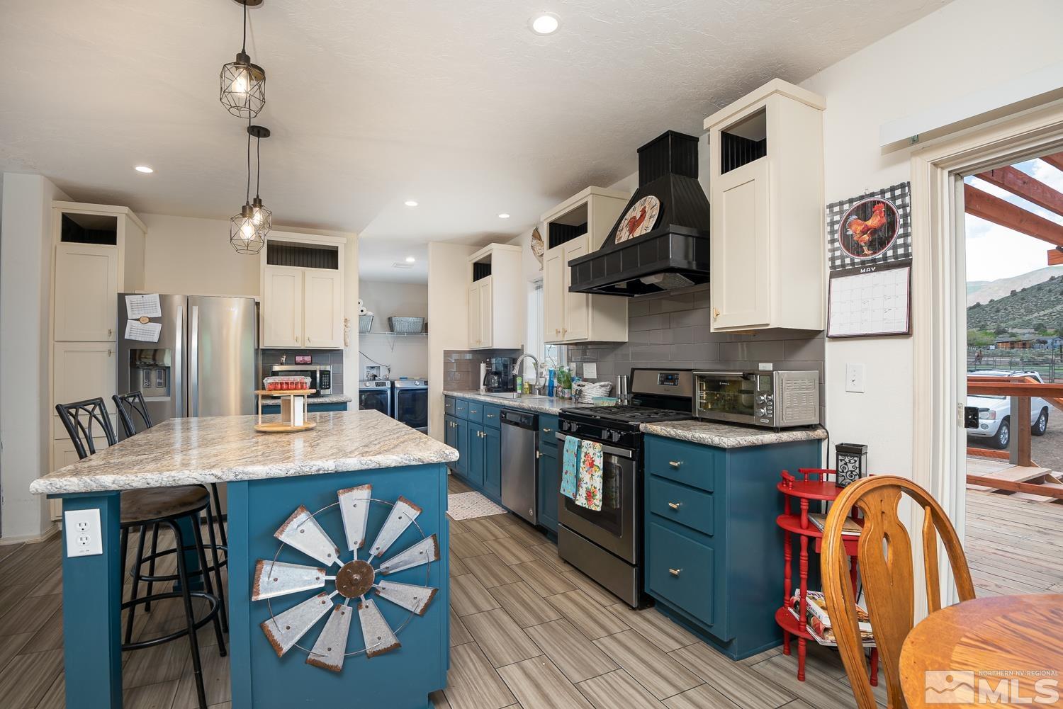 3904 Walker View Road Wellington, NV 89444 - Photo 7 of 37 a kitchen with stainless steel appliances granite countertop a stove top oven a sink a dining table and chairs with wooden floor