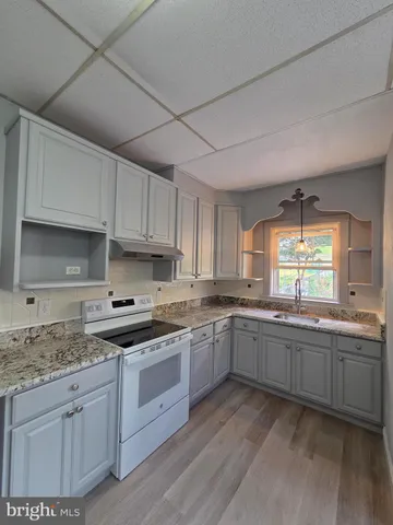 a kitchen with stainless steel appliances granite countertop a stove sink and cabinets