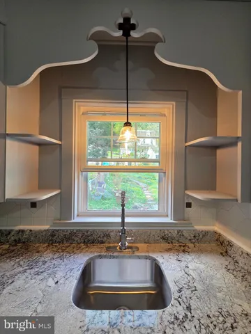 a view of a kitchen with a sink and wooden floor