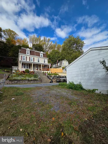 a view of a brick house with a yard and plants