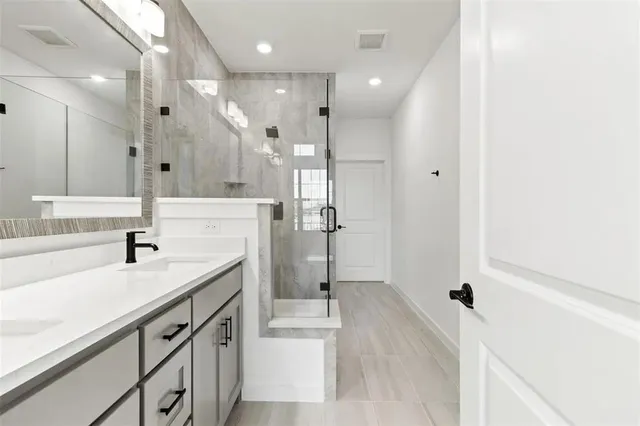 a spacious bathroom with a shower sink and mirror