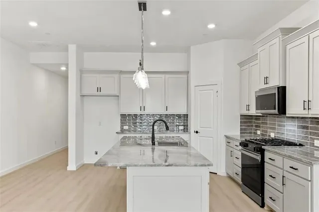 a kitchen with a sink dishwasher a stove and a refrigerator with wooden floor