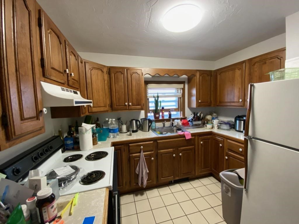 548 Pleasant Street, Unit 2R Worcester, MA 01602 - Photo 2 of 5 a kitchen with a sink a stove a refrigerator and cabinets
