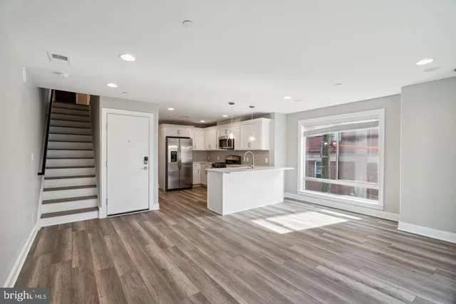 a view of kitchen with wooden floor and electronic appliances