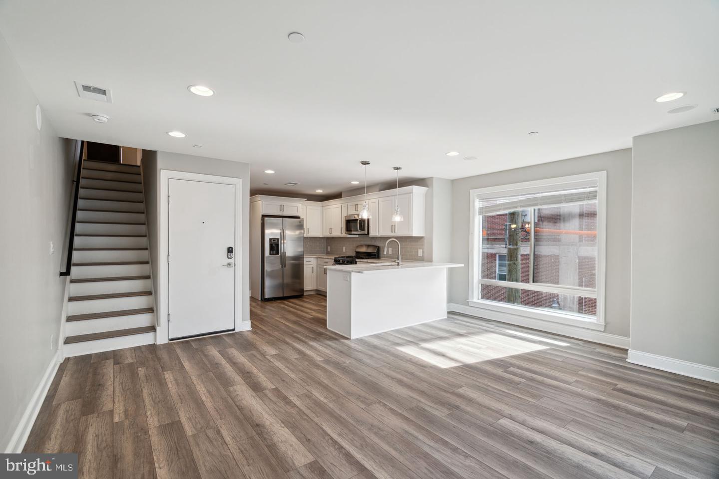 a view of kitchen with wooden floor and electronic appliances