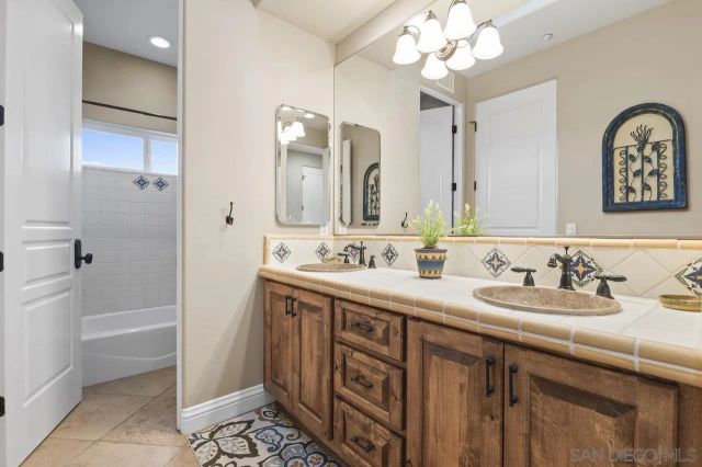 a view of a hallway with wooden floor and a bathroom