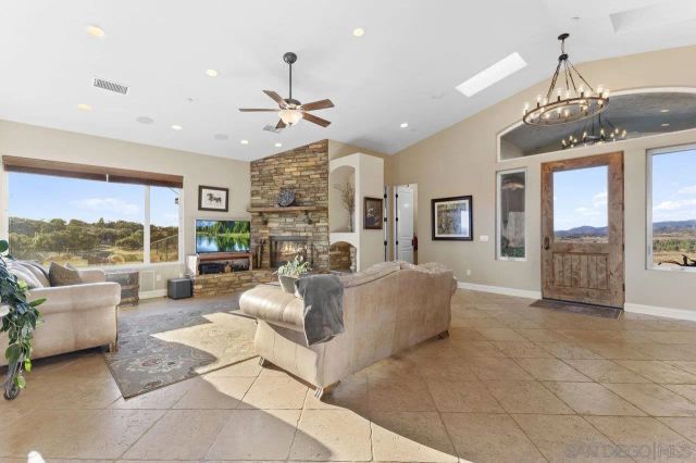 a living room with furniture a chandelier and a fireplace