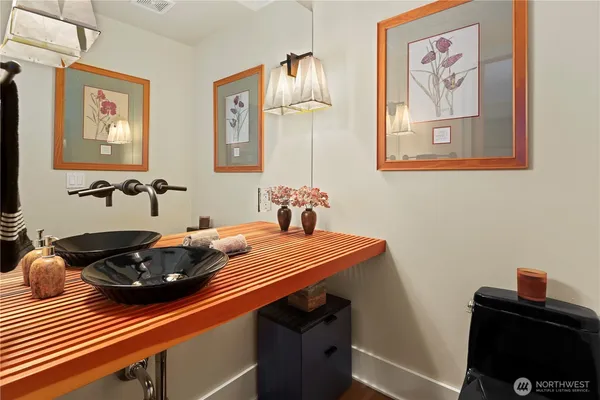 a bedroom with a bed and a lamp on dresser