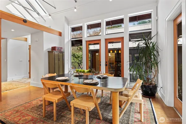 a dining room with furniture and large windows