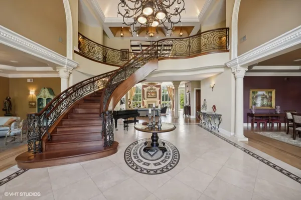 a living room with furniture a chandelier and a large mirror