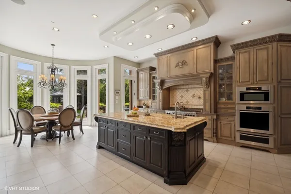 a large kitchen with kitchen island granite countertop a large counter top and stainless steel appliances