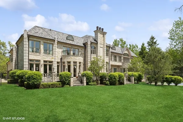 a view of a house with a big yard and large trees