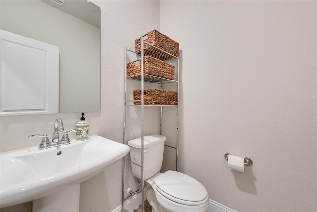 2301 Mount Olive Lane Forney, TX 75126 - Photo 15 of 36 a bathroom with a toilet a sink and mirror