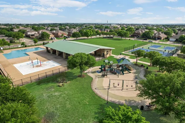 an aerial view of a tennis ground with large trees