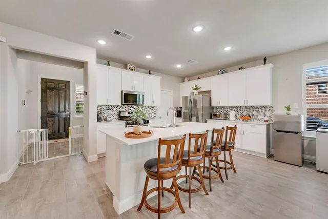 a kitchen with stainless steel appliances kitchen island granite countertop a refrigerator and a stove top oven